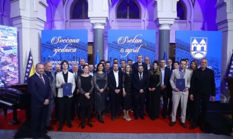 Grupa ljudi pozira za fotografiju na svečanoj sjednici povodom 6. aprila, Dana Grada Vukovara.