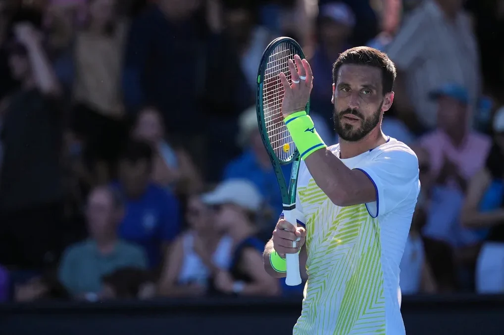 Teniser sa reketom u ruci i neonskim narukvicama.