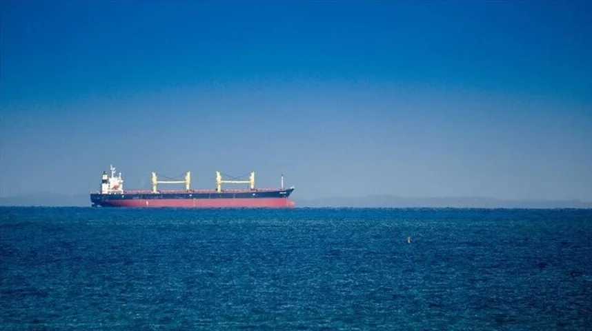 Teretni brod plovi mirnim plavim morem pod vedrim nebeskim svodom.