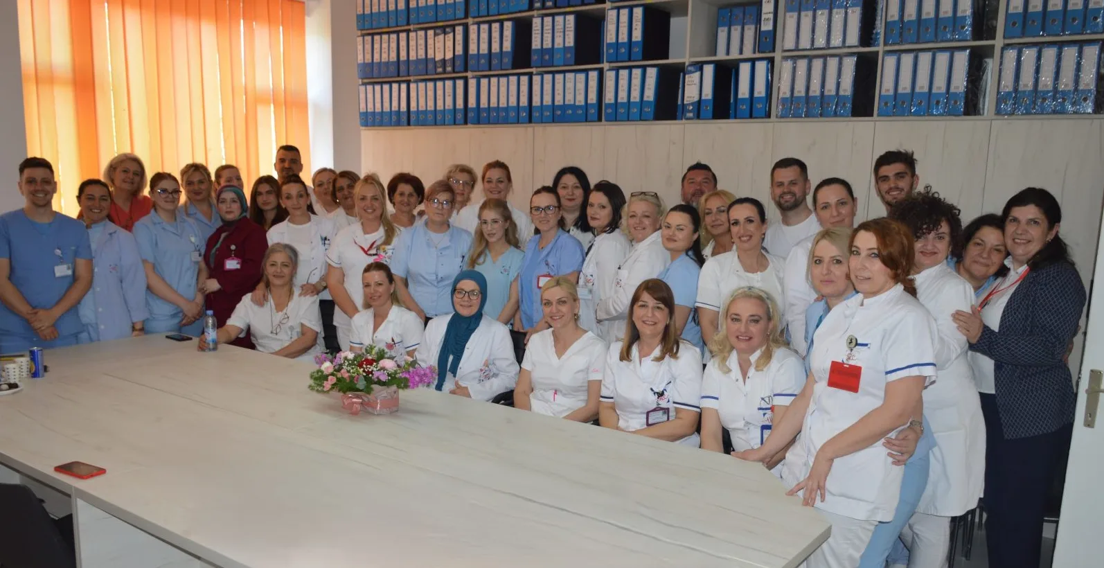 Grupa medicinskih radnika pozira za fotografiju u zatvorenom prostoru.