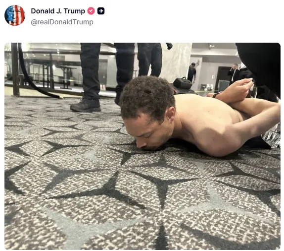 Uhapšeni muškarac na podu, licem okrenut prema tepihu, s rukama vezanim iza leđa, dok ga drže neidentifikovani službenici.