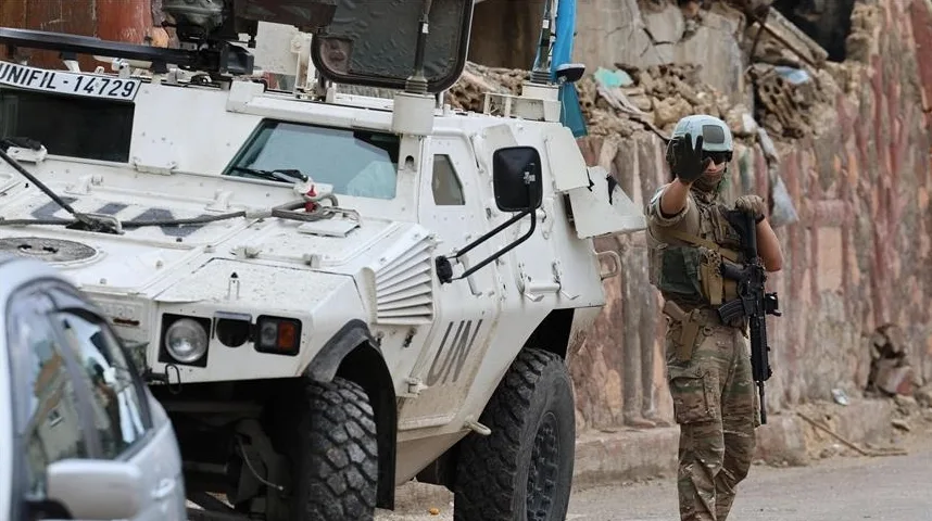 UNIFIL vojno vozilo i vojnik sa automatskom puškom pozira na ulici.