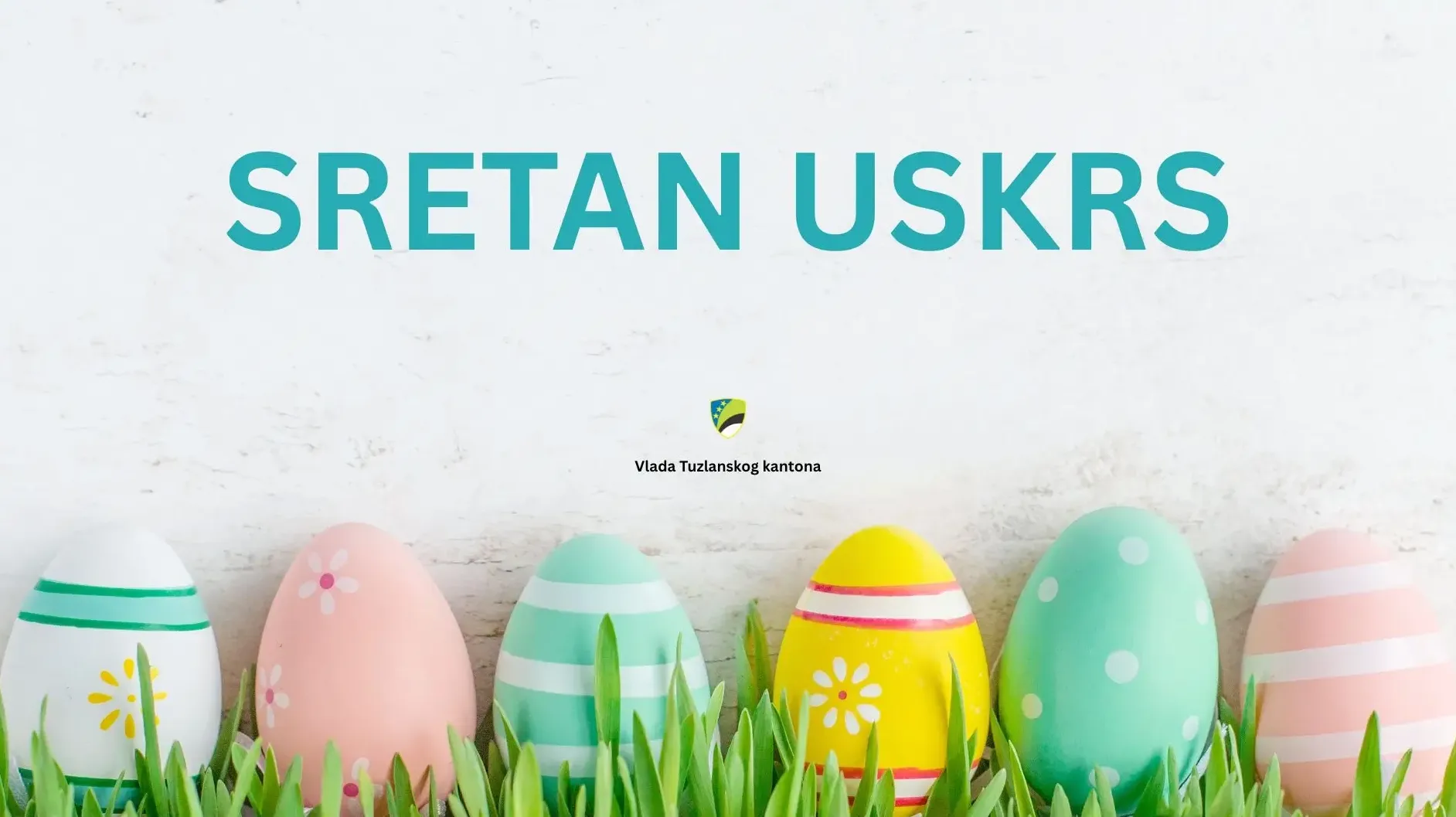 Sretan Uskrs natpis sa ukrašenim jajima i grbom Vlade Tuzlanskog kantona