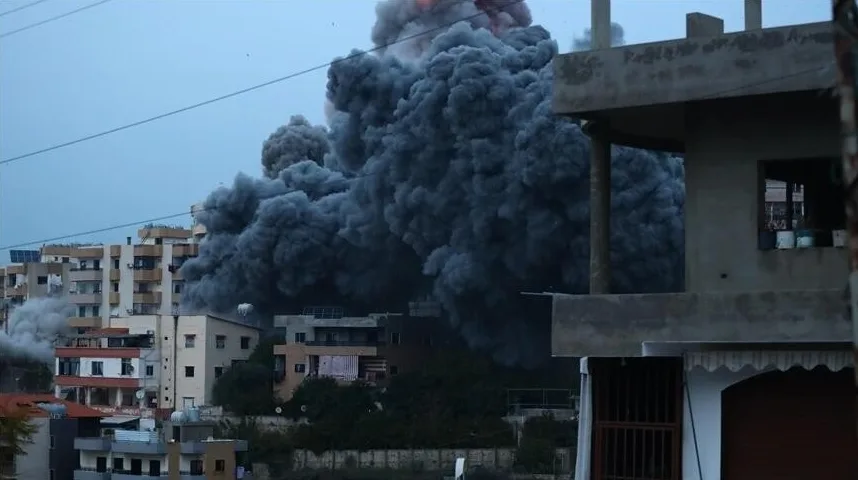 Crni gusti dim diže se visoko u nebo iznad stambenih zgrada nakon eksplozije.