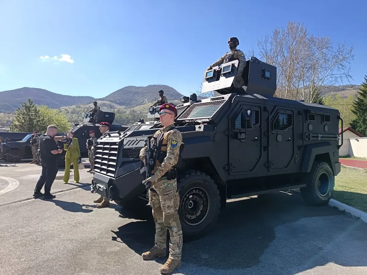 Crna oklopna vozila i vojnici u uniformama na sunčan dan