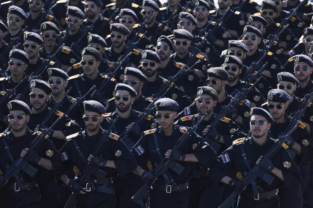 Pripadnici oružanih snaga u crnim uniformama i beretkama marširaju držeći automatske puške.