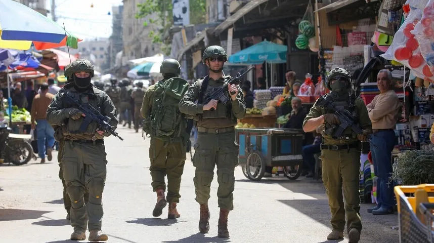 Vojnici u punoj ratnoj opremi patroliraju živopisnom tržnicom.