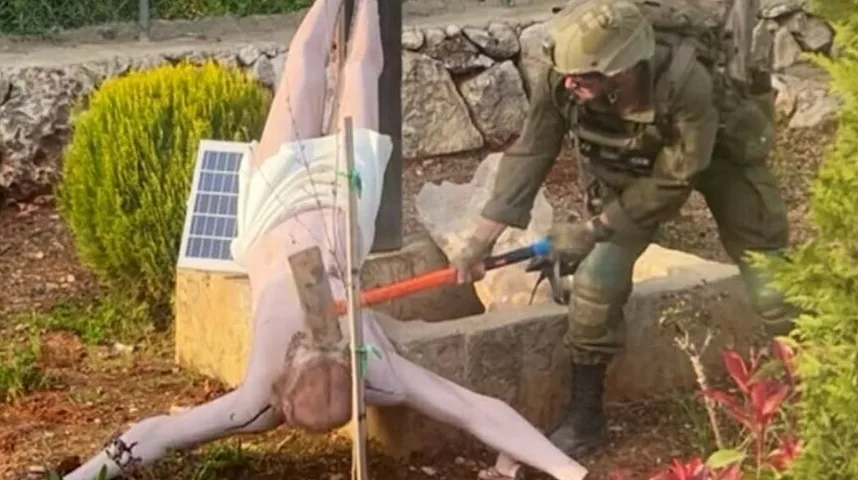 Vojnik u uniformi tuče čekićem lutku koja visi okrenuta naopako