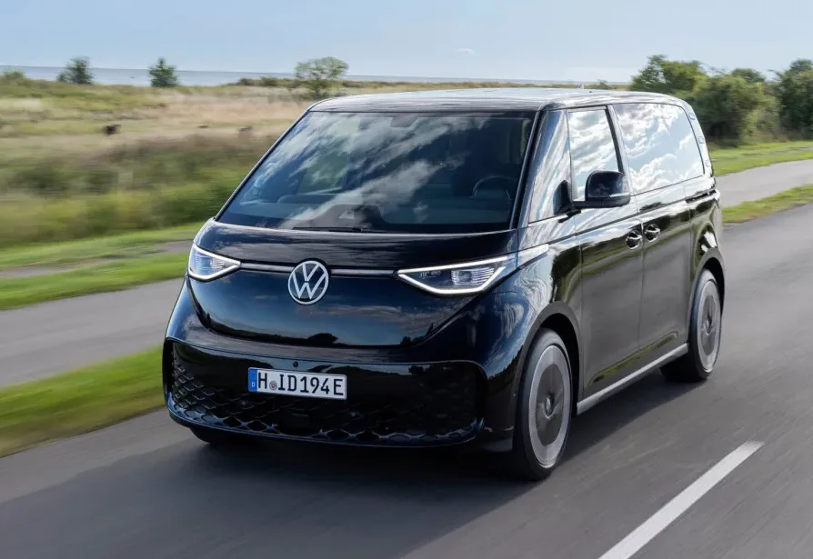Crni Volkswagen ID. Buzz kombi u pokretu na asfaltnom putu.