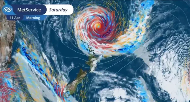 Satelitska snimka vremenske prognoze koja prikazuje snažan uragan koji se približava Novom Zelandu, s prikazom boja koje ukazuju na jačinu vjetra i padavina.