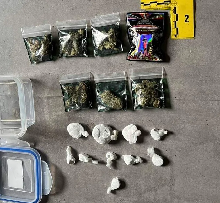 Fotografija prikazuje zaplijenjenu drogu, uključujući nekoliko vrećica s marihuanom, omotane paketiće bijele supstance i foliju s otiskom NLO-a.