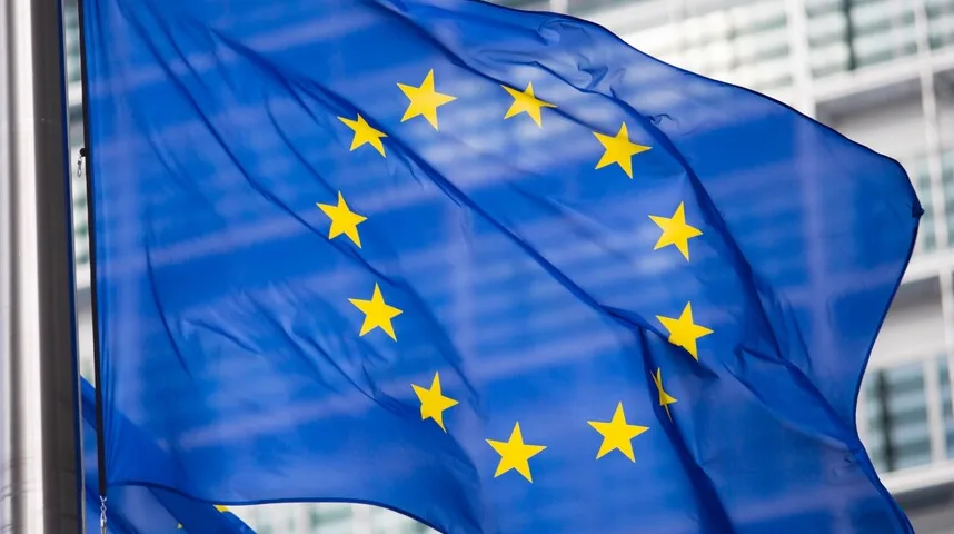 Zastava Evropske unije sa dvanaest žutih zvjezdica na plavoj pozadini koja se vijori na vjetru.