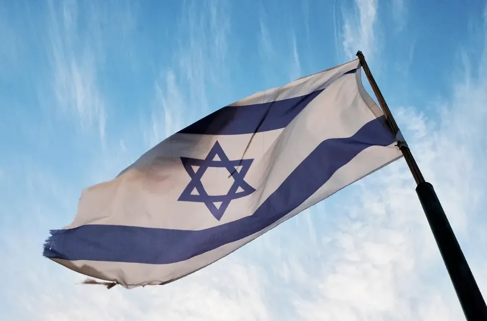 Zastava Izraela sa Davidovom zvijezdom, koja se vijori na nebu sa oblacima.