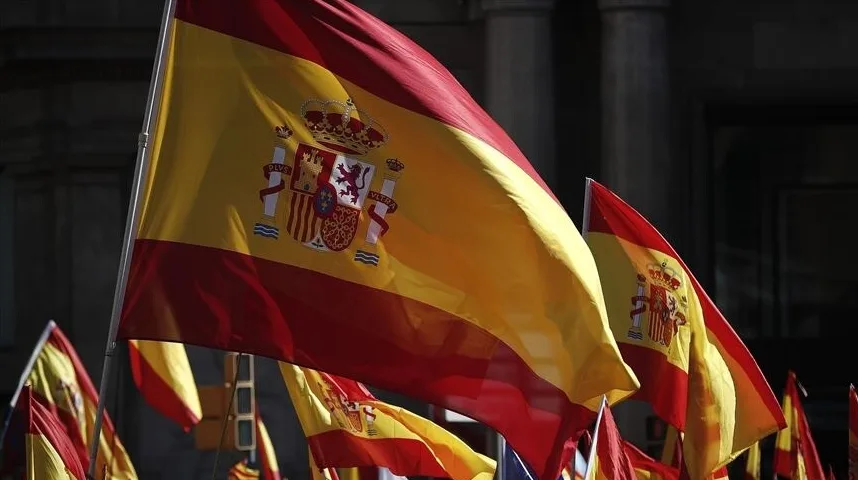 Španska zastava sa grbom i krunom koja leprša na vjetru, u pozadini se vide druge španske zastave.