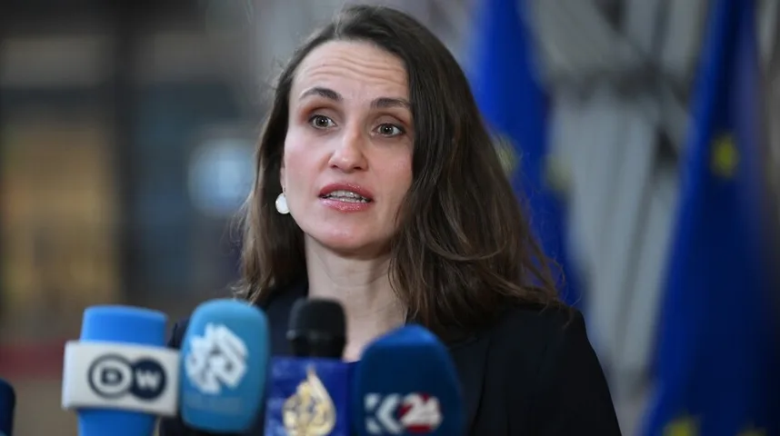 Žena govori u mikrofon pred novinarima