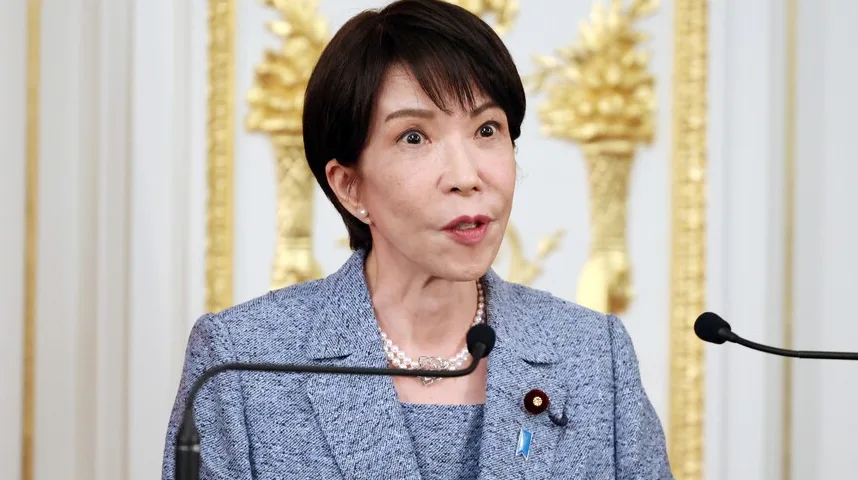 Japanka u plavom odijelu sa bisernom ogrlicom govori u mikrofon