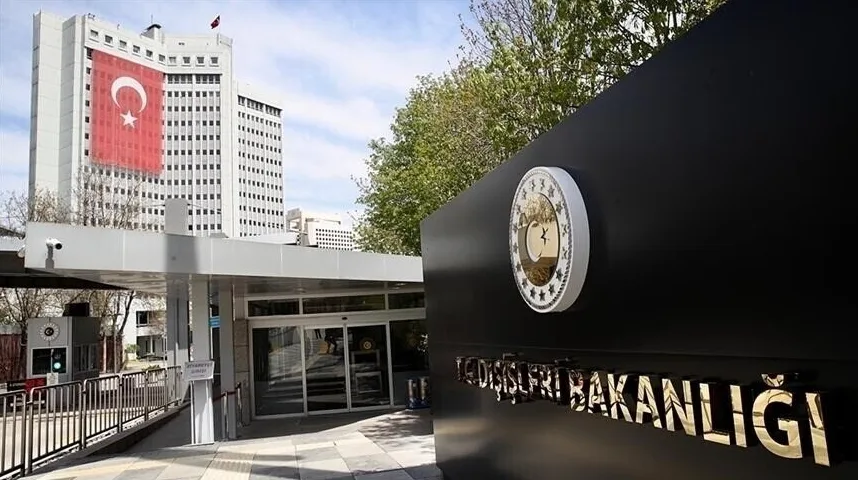 Moderna zgrada Ministarstva vanjskih poslova Turske sa turskom zastavom istaknutom na fasadi i zlatnim natpisom 'DIŠLERI BAKANLIĞI' na crnoj ploči.