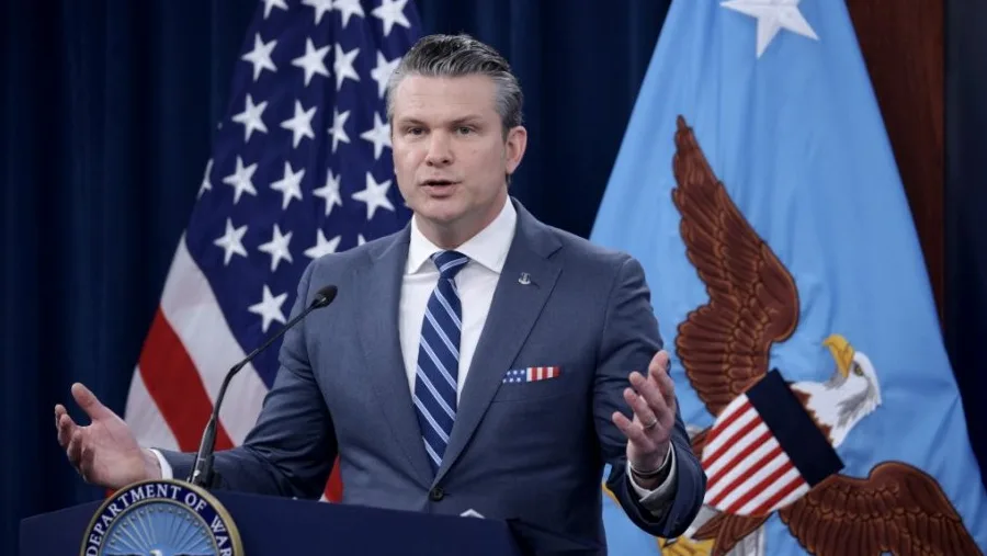Američki zvaničnik u plavom odijelu i plavoj kravati sa bijelim prugama govori za govornicom, sa američkom zastavom i zastavom Pentagona iza njega.