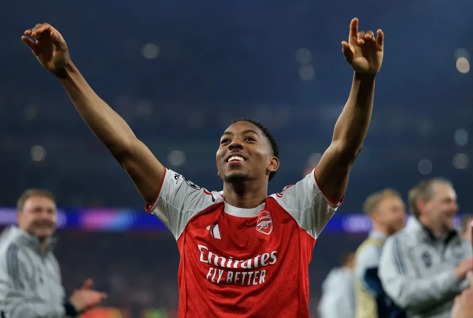 Fudbaler Arsenala, obučen u crveni dres sa bijelim detaljima i logom "Emirates Fly Better", slavi sa podignutim rukama.