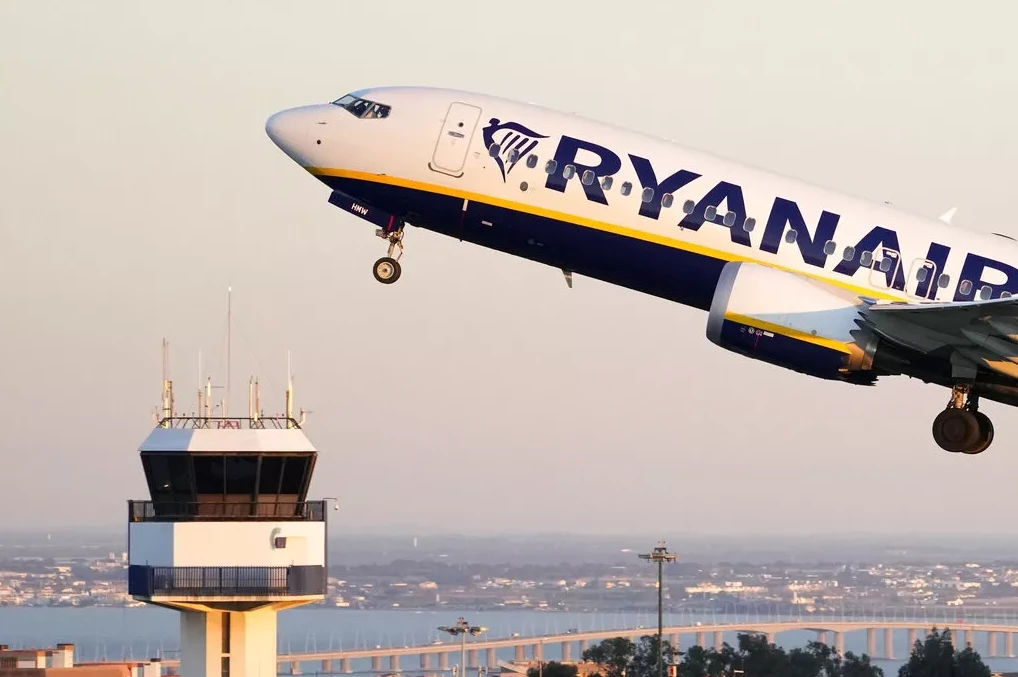 Avion Ryanair-a se diže u vazduh pored kontrolnog tornja na aerodromu.