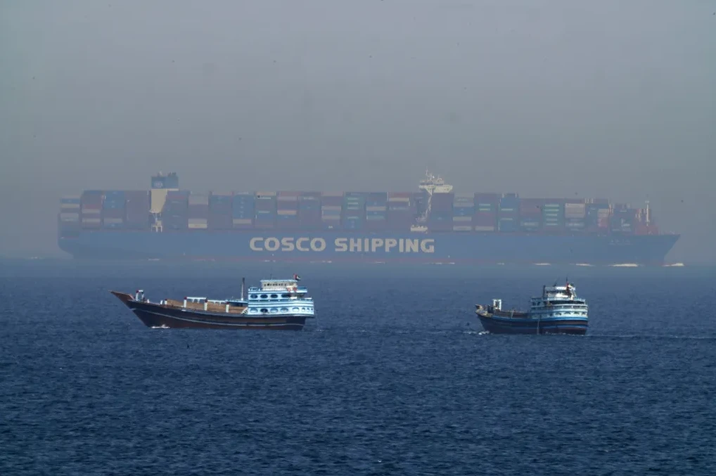 Tri broda na moru, od kojih je jedan veliki kontejnerski brod s natpisom 'COSCO SHIPPING' u pozadini, a dva manja broda u prvom planu.