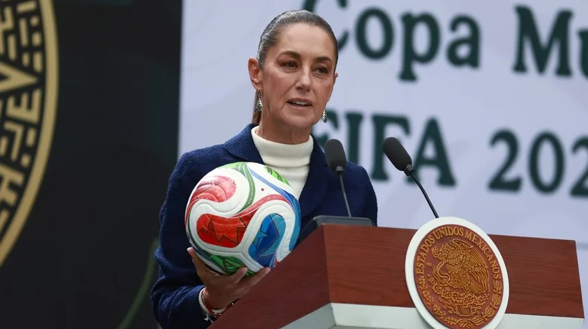 Žena drži fudbalsku loptu ispred postolja sa grbom Meksika i natpisom "Copa Mundial FIFA 2026"
