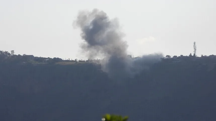 Oblak gustog crnog dima uzdiže se iznad brda na kojem se nazire naselje i telekomunikacijski toranj.