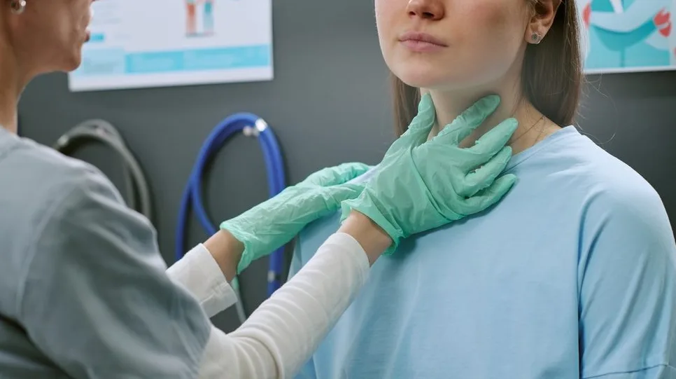 Doktor rukavicama pregleda grlo pacijentkinje