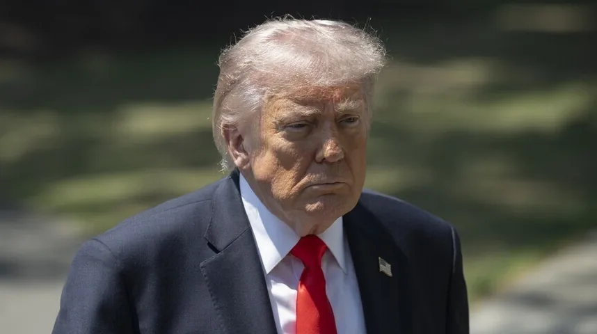 Donald Trump u tamnom odijelu i crvenoj kravati sa američkom zastavom na reveru