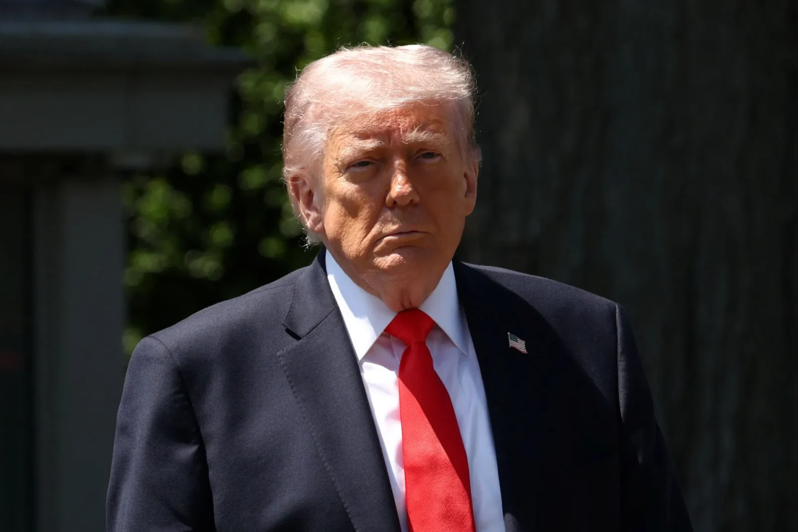 Portret Donalda Trumpa u crnom odijelu i crvenoj kravati