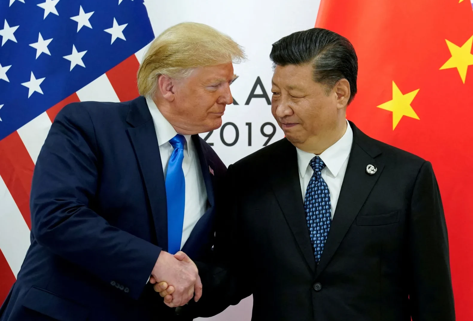 Donald Trump i Xi Jinping se rukuju pred zastavama SAD-a i Kine