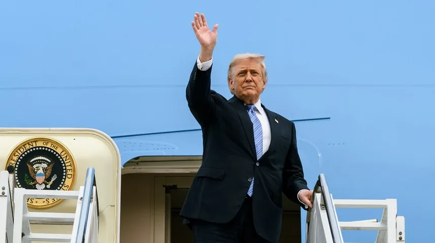 Donald Trump, bivši predsjednik Sjedinjenih Američkih Država, maše rukom dok silazi niz stepenice aviona Air Force One.