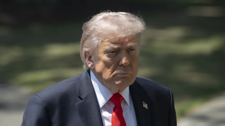 Donald Trump u tamnom odijelu i crvenoj kravati, gleda u stranu