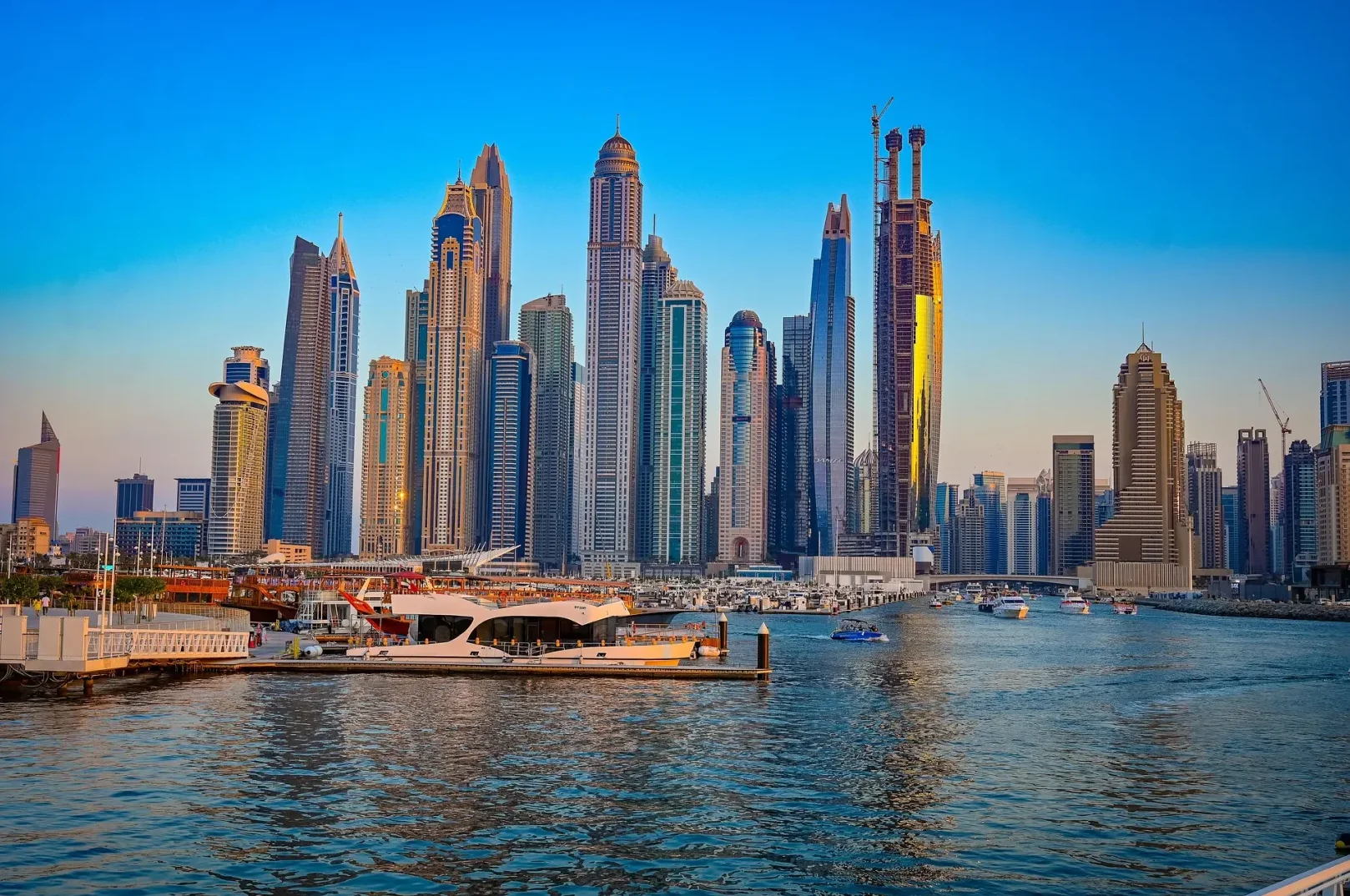 Moderna panorama Dubai Marine sa visokim neboderima odrazima zalaska sunca i jahtama na vodi