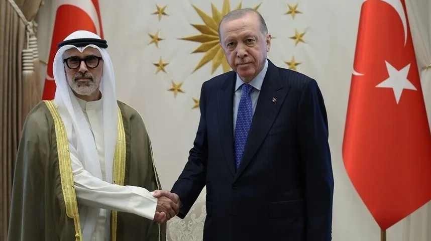 Turski predsjednik Recep Tayyip Erdoğan rukuje se sa posjetiocem u tradicionalnoj arapskoj odjeći pored turske zastave.