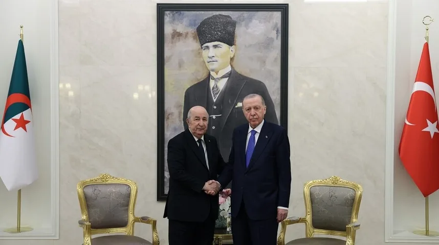 Predsjednik Turske Recep Tayyip Erdogan i predsjednik Alžira Abdelmadjid Tebboune rukuju se ispred portreta Mustafe Kemala Ataturka, sa zastavama Turske i Alžira sa strane.