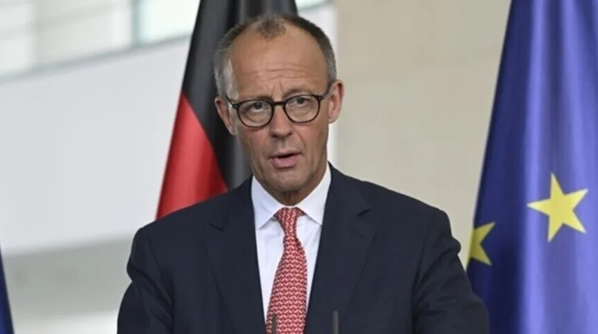 Friedrich Merz, njemački političar u tamnom odijelu, bijeloj košulji i crvenoj kravati sa šarom, nosi naočale. Iza njega se vide zastava Njemačke i zastava Evropske unije.