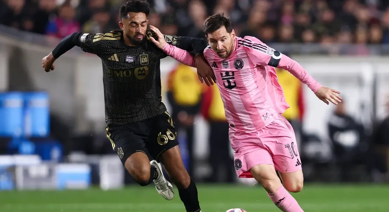 Fudbaler Lionel Mesi u ružičastom dresu Inter Majamija takmiči se s fudbalerom LA Galaksija u crnom dresu sa zlatnim detaljima.