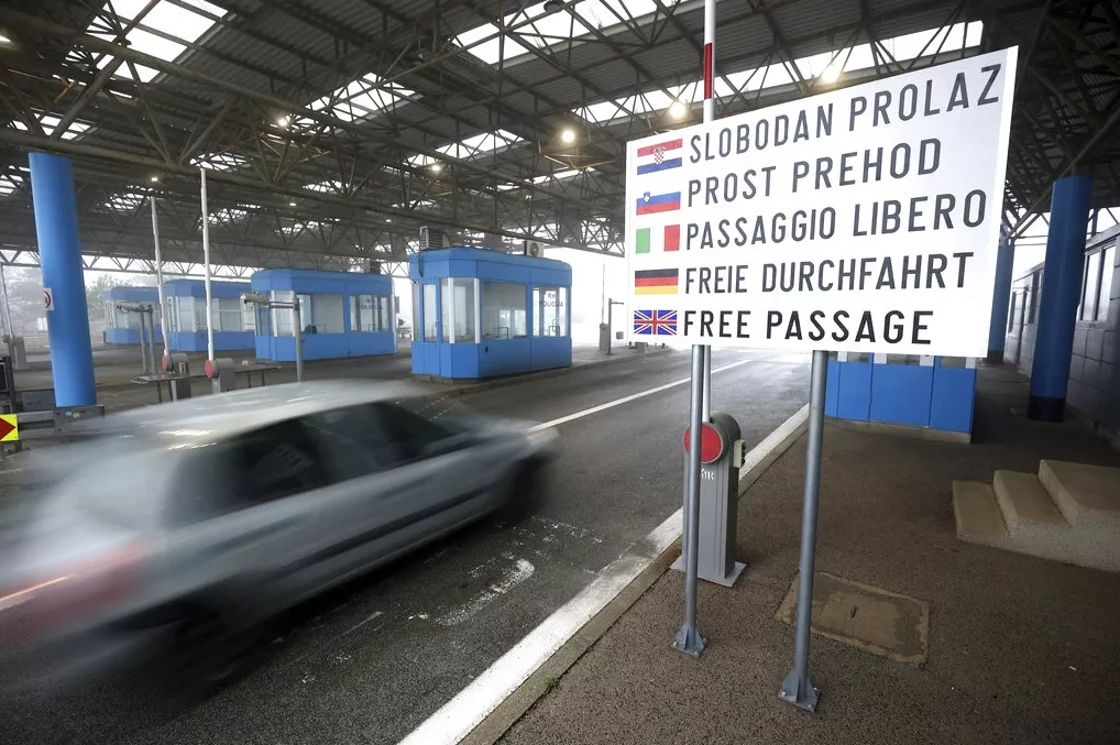 Saobraćaj na graničnom prelazu sa natpisom "Slobodan prolaz" na više jezika
