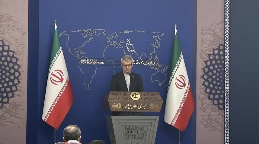 Ministar vanjskih poslova Irana za govornicom sa iranskim zastavama