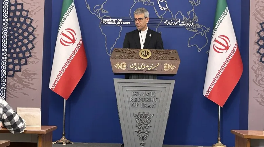 Zvaničnik Islamske Republike Iran stoji za govornicom u Ministarstvu vanjskih poslova, sa zastavama Irana sa obje strane.
