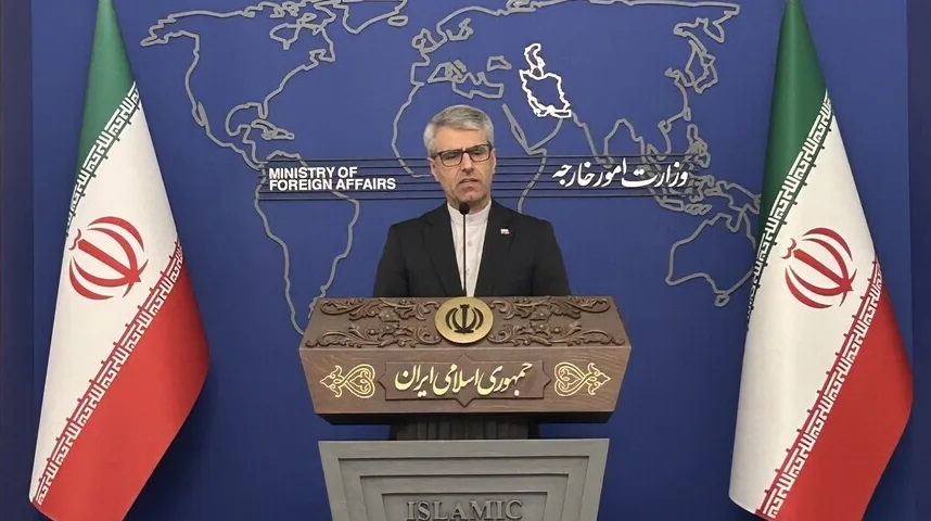 Portparol iranskog Ministarstva vanjskih poslova drži govor iza postolja sa grbom Islamske Republike Iran.
