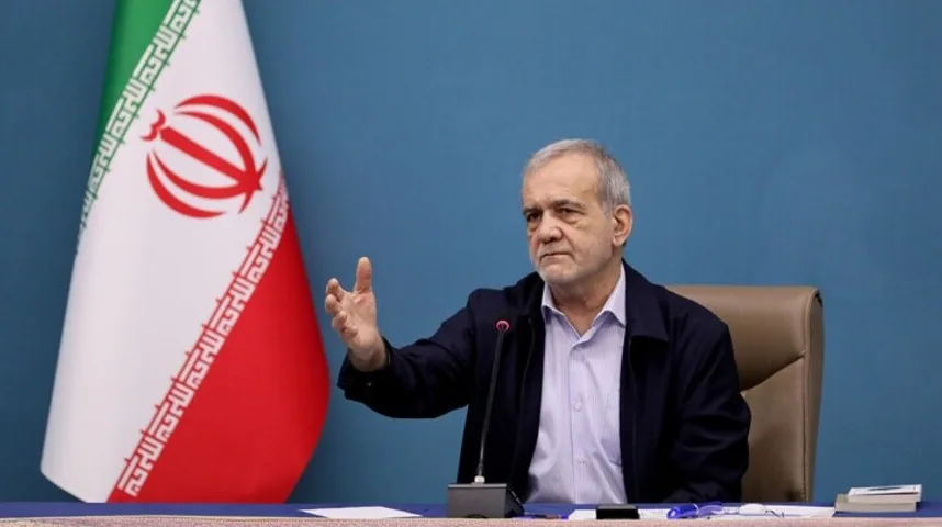 Iranski političar koji govori pored zastave Irana.