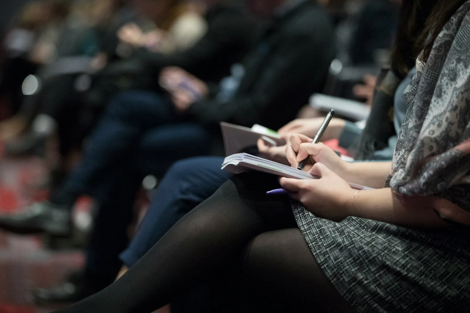 Ruka žene koja piše u bilježnici tokom konferencije