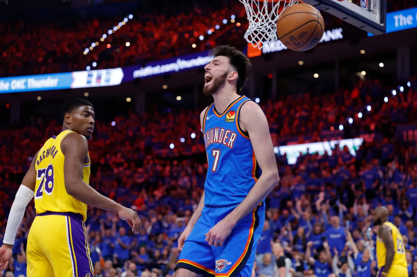 Košarkaš Oklahoma City Thundera sa brojem 7 na dresu slavi pogodak dok ga gleda igrač Los Angeles Lakersa sa brojem 28.