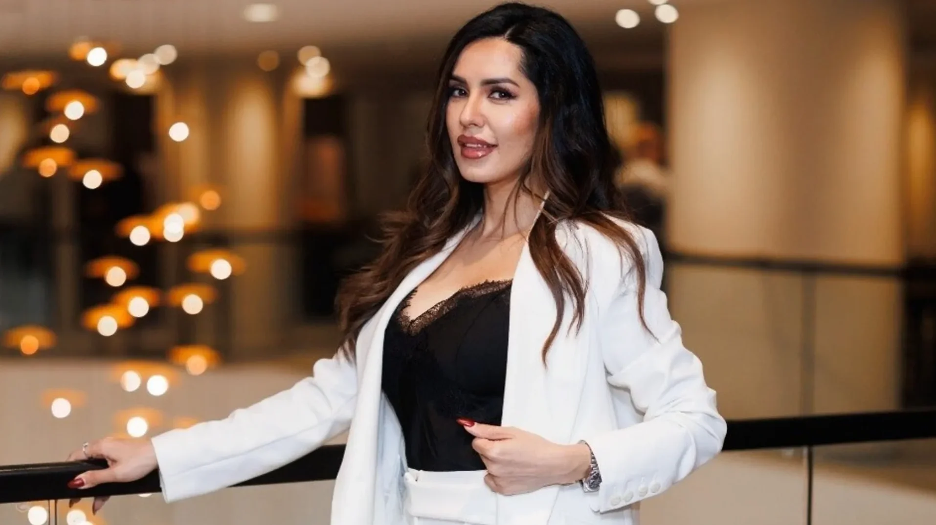Elegantna žena u bijelom sakou i crnom topu sa čipkom