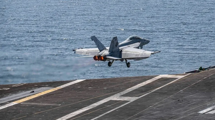 F/A-18 Hornet lovac uzlijeće sa palube nosača aviona, sa mlazom izduvnih gasova.