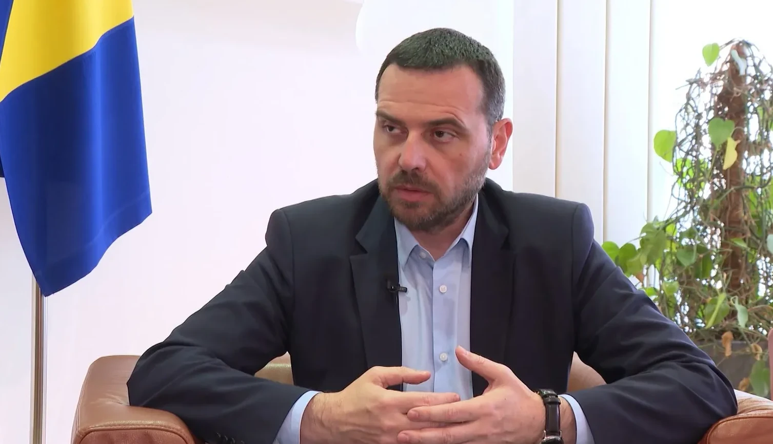 Čovjek u odijelu sa zastavom Bosne i Hercegovine