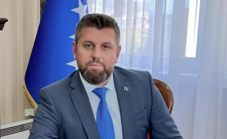 Portret zvaničnika sa zastavom Federacije Bosne i Hercegovine u pozadini