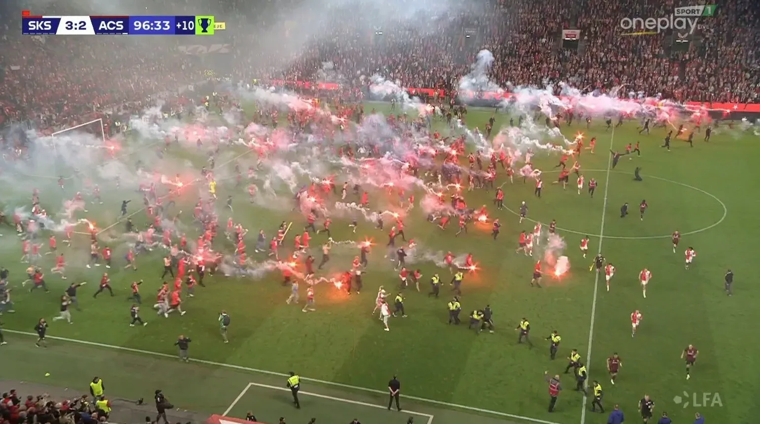 Navijači utrčavaju na nogometni teren usred gustog dima od baklji, u trenutku kada je rezultat 3:2